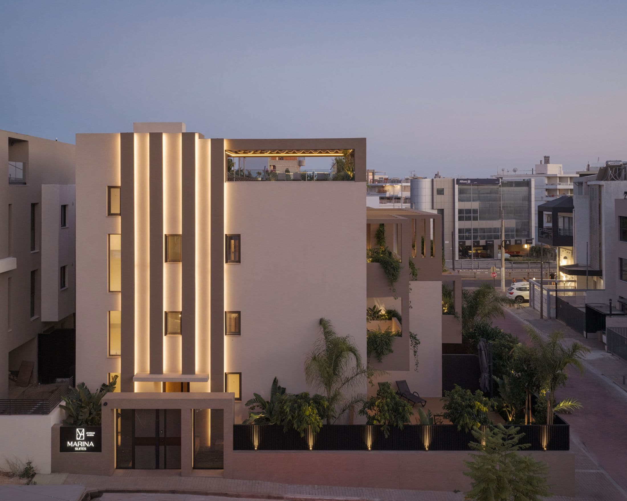 Η φωτισμένη όψη του Marina Suites από τον δρόμο, το βράδυ